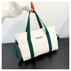 Détail du sac cabas en toile blanche avec anses vertes et texte de mode noir