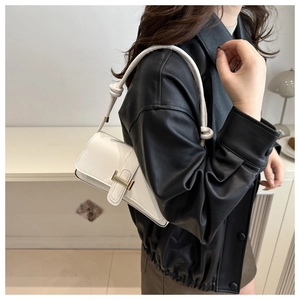 Detail of white leather shoulder bag with gold H-buckle and knotted rope strap