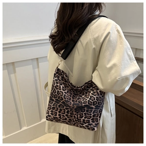 Macro detail of vintage leopard print hobo bag with a wide black strap and gold metal buckle