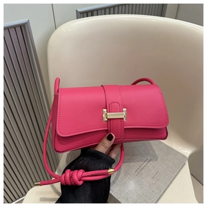 Detail of hot pink baguette bag with gold buckle and woven rope shoulder strap