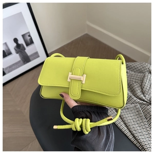 Detail of lime green leather shoulder bag with golden H buckle and braided strap