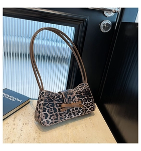 Detailaufnahme der Hobo-Tasche mit Leopardenmuster, Leder-Schleife und schmalen Gurten