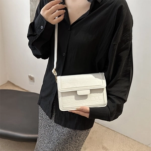 White crocodile pattern small square crossbody bag shown on a model with a black shirt