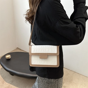 Chic white crocodile embossed crossbody bag with brown trim shown on a model