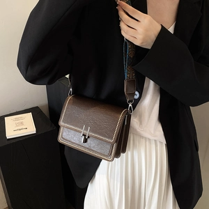 Vintage brown crossbody bag with textured faux leather and wide geometric printed strap