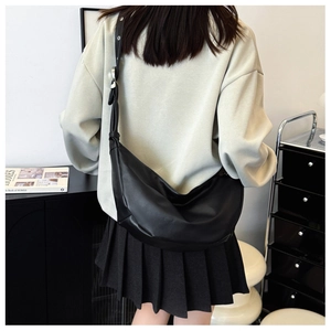 Detailed view of black matte hobo bag with wide shoulder strap and silver buckle