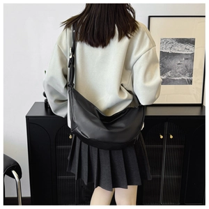 Modern black crescent crossbody bag in soft vegan leather with minimalist styling