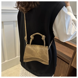 Detailed view of brown retro small square bag featuring unique wave bottom and knot handle