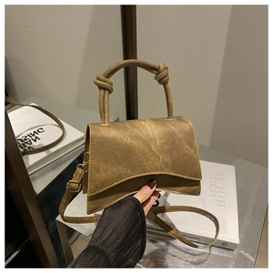 Detail of the vintage brown handbag featuring a twisted knot handle and gold hardware