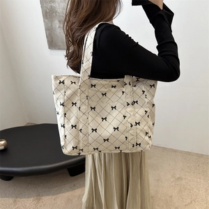 Schicker beige Cord-Shopper mit Schleifenprint und Steppmuster an einem Frauenmodell