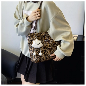 Detailed shot of leopard print tote bag with white cloud plush charm and side leather tag
