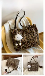 Detail of leopard print canvas tote bag featuring brown finish and plush cloud charm