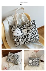 Detail of leopard print tote bag featuring a white leather strap and plush cloud charm