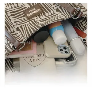 Interior view of striped canvas tote showing large capacity for phone and cosmetics