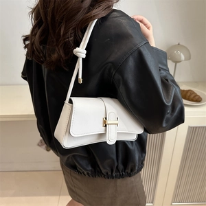 White minimalist crossbody bag with gold H-buckle and knotted strap on female model