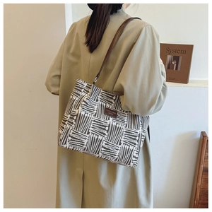 Detail of printed tote bag with brown leather strap and stylish geometric patterns