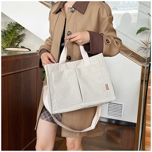 Dettaglio della borsa tote in velluto a coste bianco con due tasche e etichetta in pelle