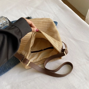 Detail view of woven straw bag interior showing fabric lining and zipper pocket