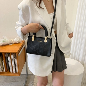Chic black crocodile embossed crossbody bag for women with gold logo and woven handle