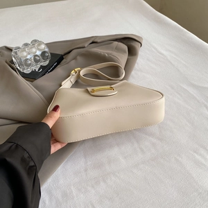 Close-up of beige minimalist underarm bag with gold metal buckle on lifestyle background