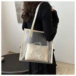 Detail of transparent PVC tote with cream fabric insert and white bear graphic design