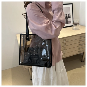 Detailed side view of a black transparent PVC tote bag featuring a 3D bear relief design