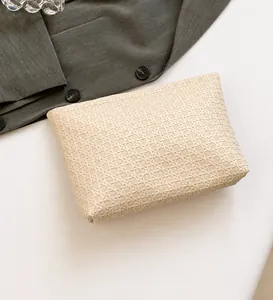Close-up of cream woven texture on a minimalist large capacity clutch handbag