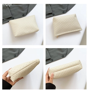 Detail view of beige woven texture handbag with zipper closure and spacious bottom design