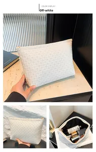 Detail of cream woven texture envelope clutch bag with gold zipper and large capacity