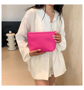Close-up of rose pink envelope clutch featuring diamond woven texture and rectangular shape