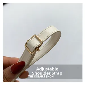 Detailed macro view of adjustable cream leather strap with gold metal buckle hardware