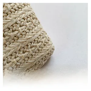 Close-up of the high-quality woven straw texture and natural beige fibers on the bag