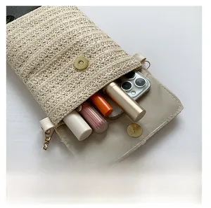 Straw crossbody bag interior showing space for smartphone and lipsticks