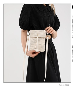 Detail of cream straw crossbody bag with long tassels and rectangle flap closure