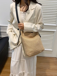 Minimalist beige woven straw tote bag with black straps for summer vacation fashion