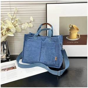 Dettaglio della borsa tote in velluto a coste blu con due tasche frontali e tracolla