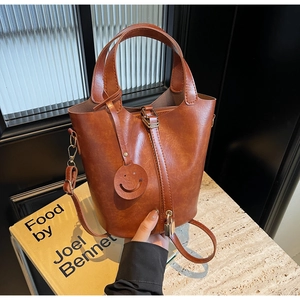 Sac seau vintage marron caramel avec fermoir métallique sur table en marbre