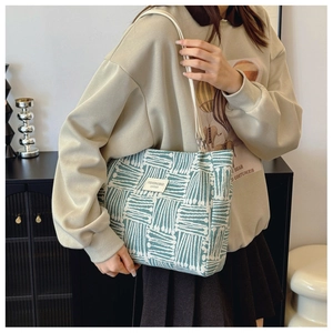 Detail of green geometric canvas tote bag showing the side view and large capacity size