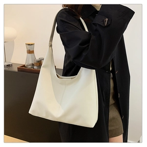 Detail of a minimalist creamy white hobo bag with high-quality textured PU leather and stitching