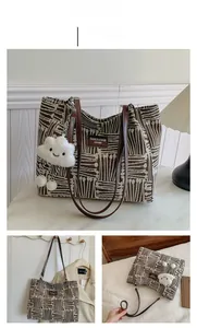 Detail view of coffee canvas tote bag with leather straps and cloud plush charm