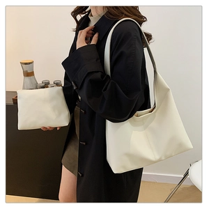 Detailed side view of off-white PU leather tote bag set shown on a model's shoulder
