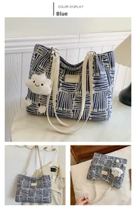 Blue geometric knit tote bag detail with white leather straps and cloud charm