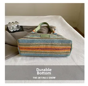 Detailed view of the wide wear-resistant bottom on the rainbow striped woven tote bag