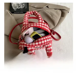 Internal storage of red gingham mini bag showing phone and cute plush pendant charm