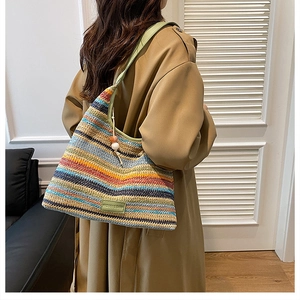 Detail of colorful woven tote bag with green leather strap and fashion label on front