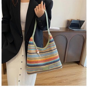 Detail of colorful striped woven tote bag with mint green straps and beaded charms