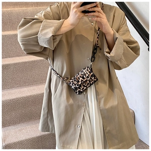 Detail of mini leopard print crossbody bag with black chain strap on model