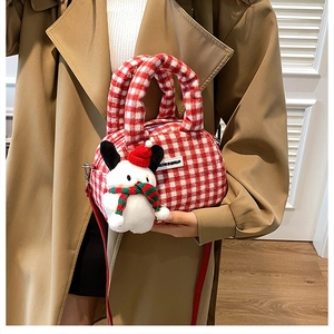 Detail der rot-weiß karierten Plüschhandtasche mit Schneemann-Anhänger und Gurt