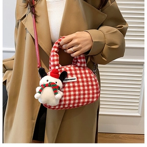 Detail der rot-weiß karierten Stofftasche mit einem niedlichen Plüschbär-Anhänger Dekor