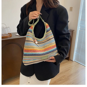 Close-up of bohemian colorful striped woven tote bag with green leather strap and beads